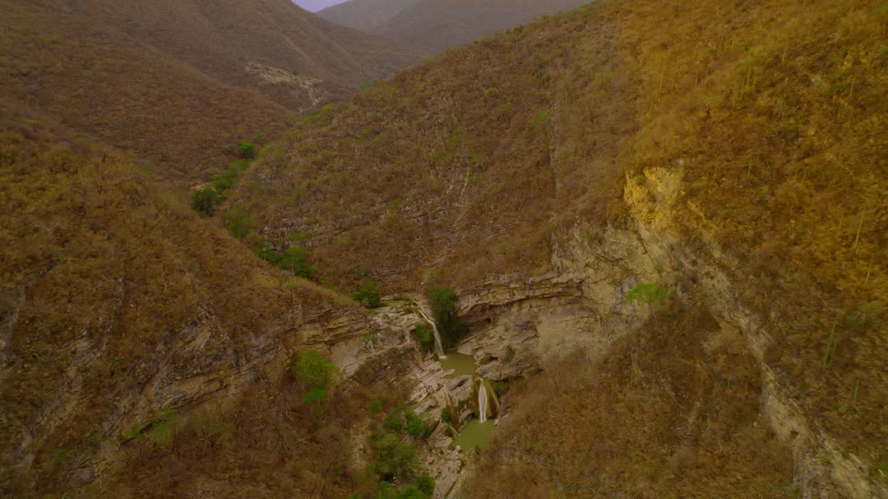 imágenes de drones de una cascada en medio de las montañas desérticas
