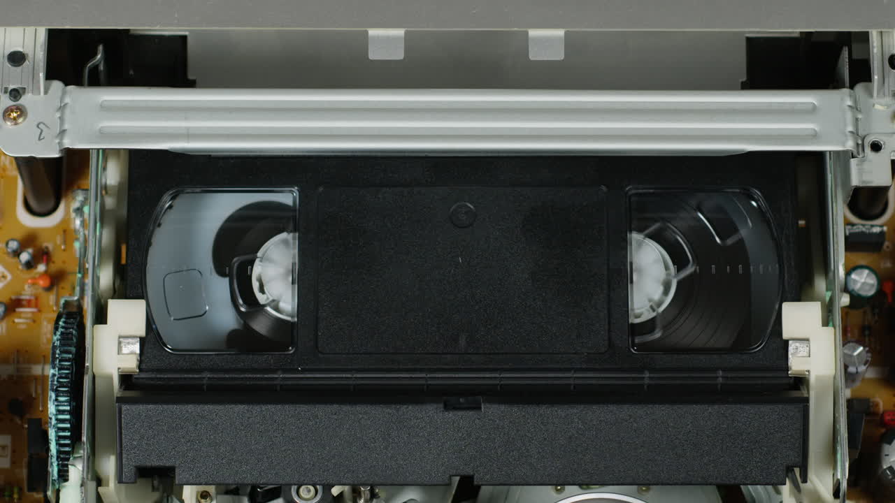 Old video recorder inside close-up, VHS. Retro player in neon blue light, vintage video cassette broadcasting, audio tape.