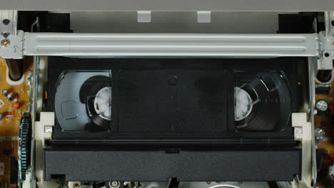 Old video recorder inside close-up, VHS. Retro player in neon blue light, vintage video cassette broadcasting, audio tape.