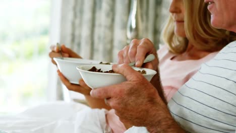 Smiling-couple-having-breakfast-on-bed