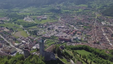 vista panorámica aérea de borgo valsugana en trentino italia con vistas a la ciudad y las montañas, drone volando hacia atrás