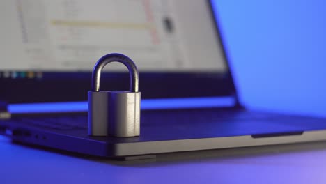 locked metal padlock on a laptop keyboard over blue background. cyber security, antivirus software concept.