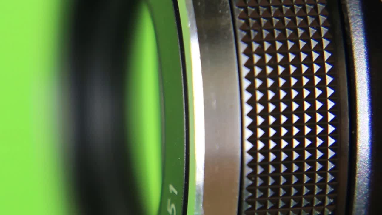 перемещение регулировочных колец на объективе видеокамеры на зеленом фоне-1