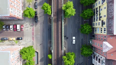 pedestrians cross the street elevated train car passes