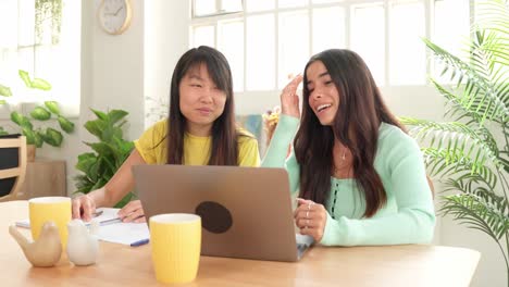 Two women working together on a laptop