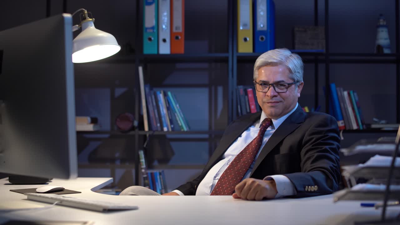 un uomo d'affari che guarda la telecamera e ride.