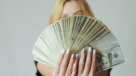 beautiful girl with a lot of dollars in the hands on the white background