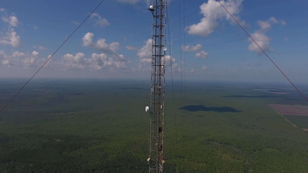 disparo de drone alejándose de una torre de comunicación