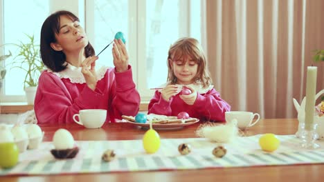 mother and daughter painting easter eggs