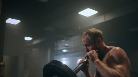 Mann-Macht-Eine-Einarmige-Landminen-Kniebeuge-zu-Presse-Übung.-Mann-Macht-Langhantelübungen-Im-Fitnessstudio.-Starker-Mann-Macht-Landminenübungen-Mit-Langhantel.