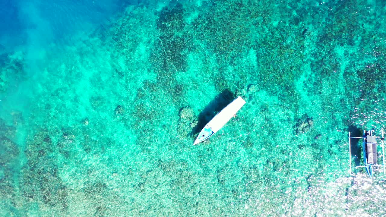 barcos de turismo flotando sobre el agua esmeralda cristalina de la laguna turquesa llena de arrecifes de coral y guijarros en el fondo del mar en malasia