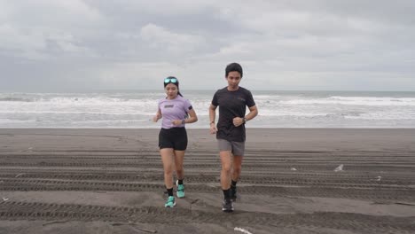 pareja corriendo en la playa