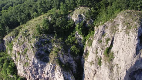 aerial tilt down of karst mountain with a wooden hanging bridge in between