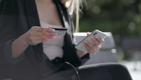 cropped shot of girl holding credit card and using smartphone