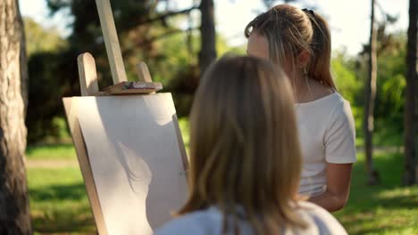 teen girls painting in a park