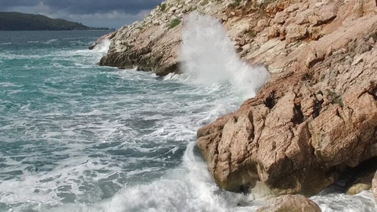 Onde che si infrangono contro le rocce su una costa tempestosa