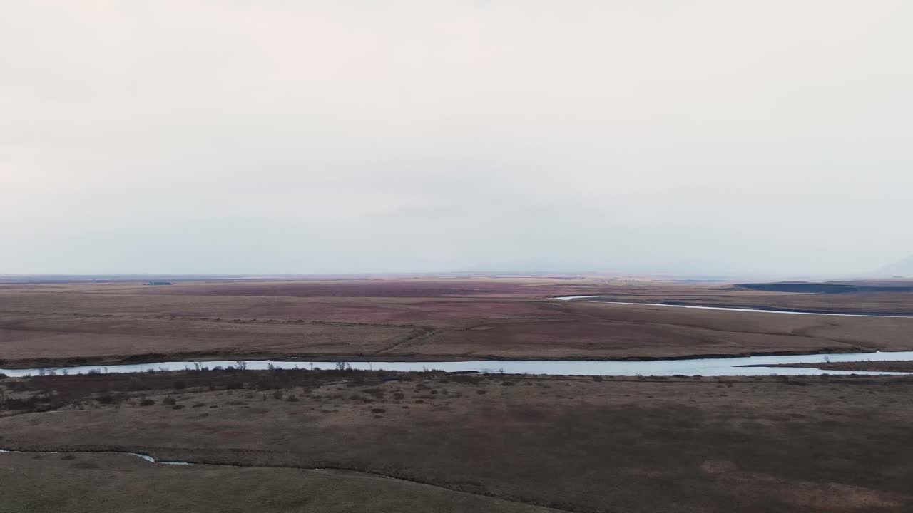 River between wide plains and fields in cloudy weather, Iceland