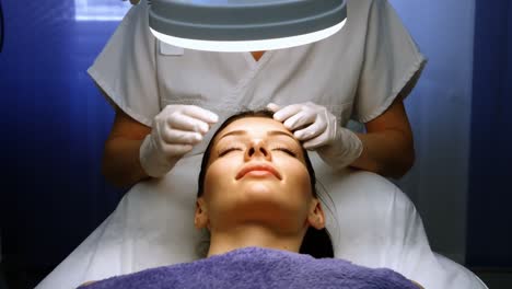 doctor examining female patient skin