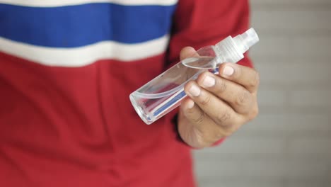 person holding a hand sanitizer spray bottle