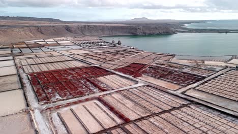 beautiful aerial drone footage of the salinas de janubio salt flats at sunset in lanzarote, canary islands, spain.