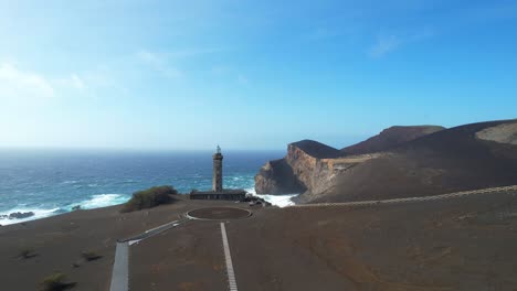 drone volando hacia farol da ponta dos capelinhos en la isla de faial