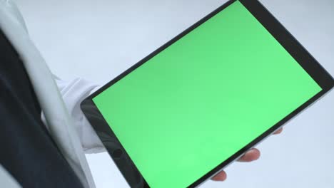 person holding tablet with green screen and stylus