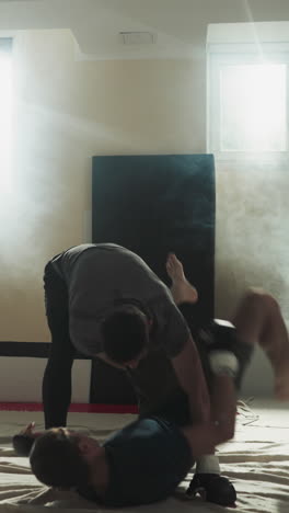 스포츠 클럽에서 공격하는 파트너를 던지고 때리는 남자. mma 스포츠 선수들이 안개에 잠긴 체육관에서 스파링 액션을 하고 있습니다. 프로 운동 선수 전투.