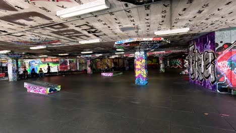 patinadores realizando trucos en un parque de patinaje cubierto de graffiti