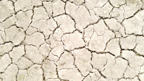 dry cracked drought fractured land aerial view flying over hot barren environment