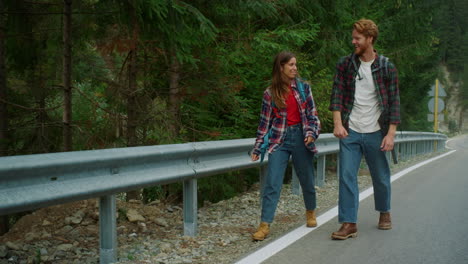 two hikers travel road in mountains. smiling tourists trekking in forest nature.