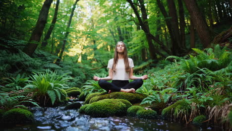 woman meditating in a tranquil forest stream