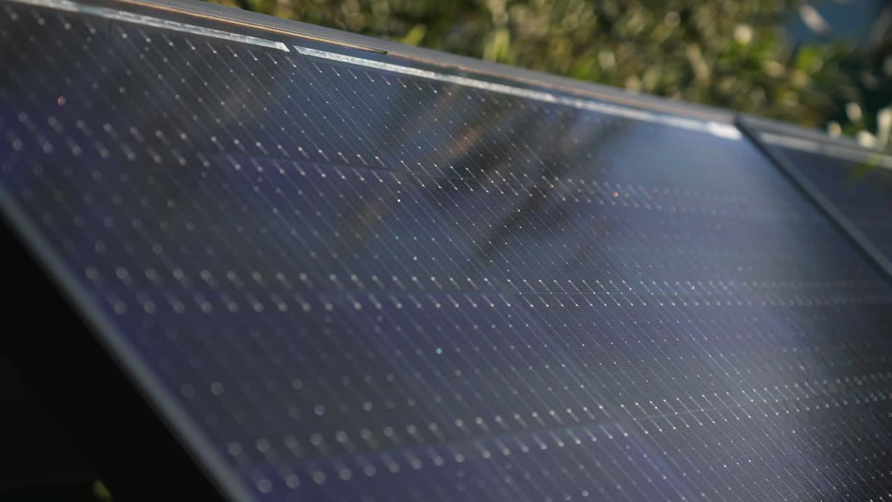 Primo piano di un moderno pannello solare illuminato all'aperto dalla luce del sole - carrellata.