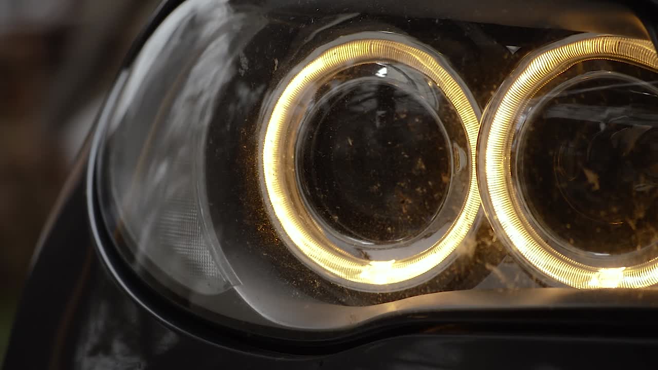 겨울 저녁에 전면 주차등이 켜진 자동차 주변, 카메라가 오른쪽에서 왼쪽으로 패닝