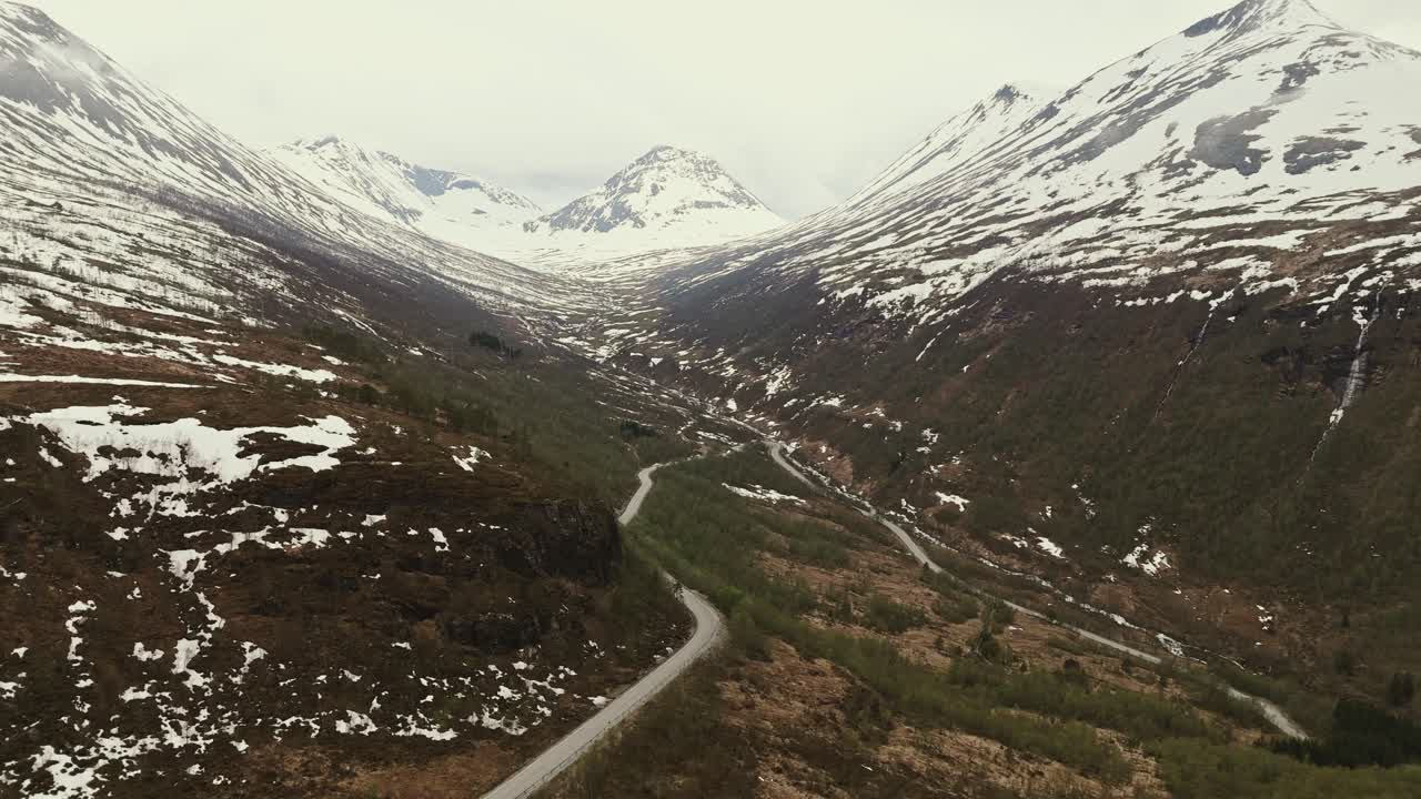 montañas nevadas y carreteras sinuosas en noruega, vista aérea