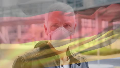 Animation-Der-Flagge-Deutschlands,-Die-über-Einem-Kaukasischen-Mann-Mit-Gesichtsmaske-In-Der-Stadtstraße-Winkt