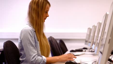 estudiante feliz trabajando en una computadora