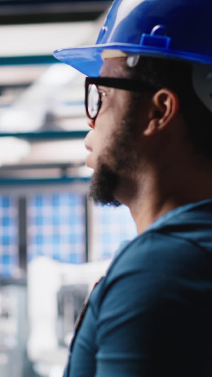 Vertical Video Black photovoltaics factory technician looking over paperwork documents