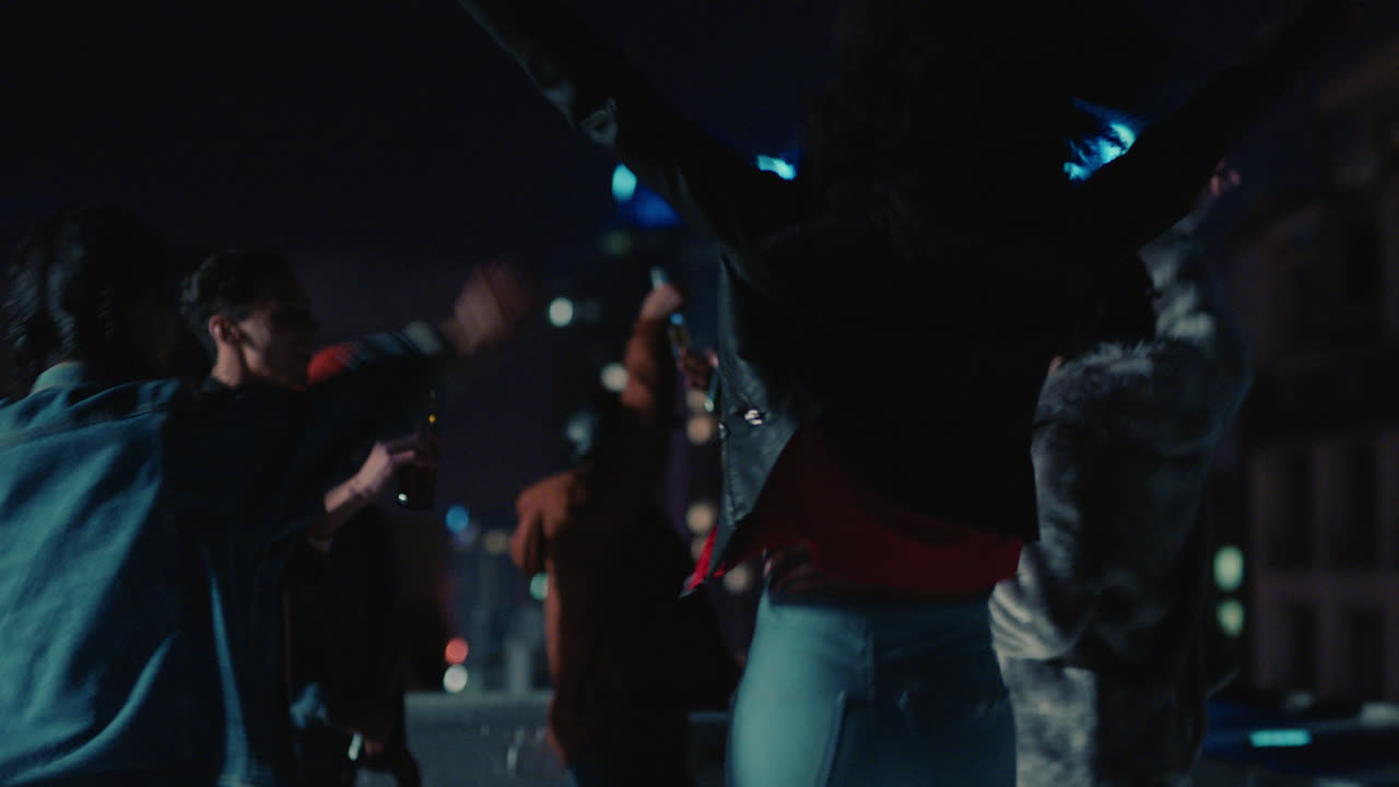 grupo feliz de amigos bailando a la música animada de la fiesta en la azotea disfrutando de la celebración del fin de semana en la ciudad urbana por la noche