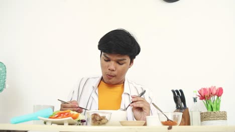 young man enjoying a delicious noodle soup meal at home