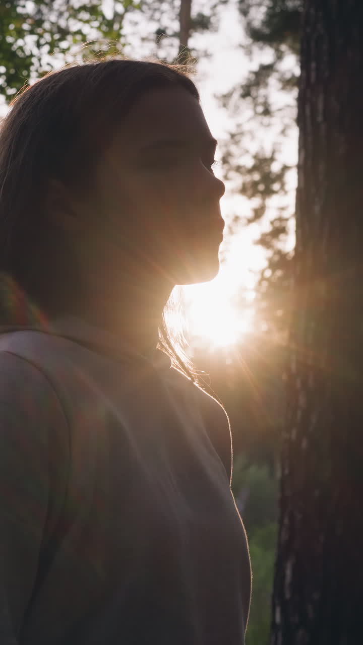 Donna triste passeggia nel bosco al tramonto. Una giovane donna riposa in una fitta foresta pensando da sola al significato della vita. Sensazione di vuoto e solitudine.