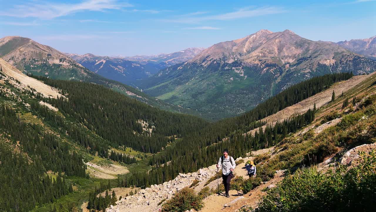 Hiker hiking La Plata Peak Gulch Trail 14er view of Independence Pass Sawatch Range 14er spring summer Rocky Mountains Colorado high alpine elevation treeline morning blue sky haze static shot