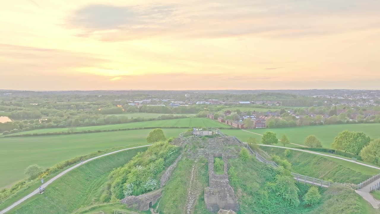 Aerial ascend reveal of ancient mound with castle ruins and surrounding countryside, Sandal Castle Wakefield UK