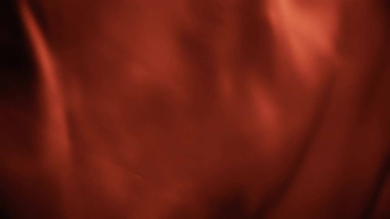 Red chiffon textile waving in the wind. Abstract texture background.