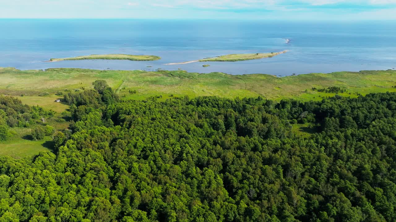 Flying over a forest towards two islands close to the coast, Baltic sea