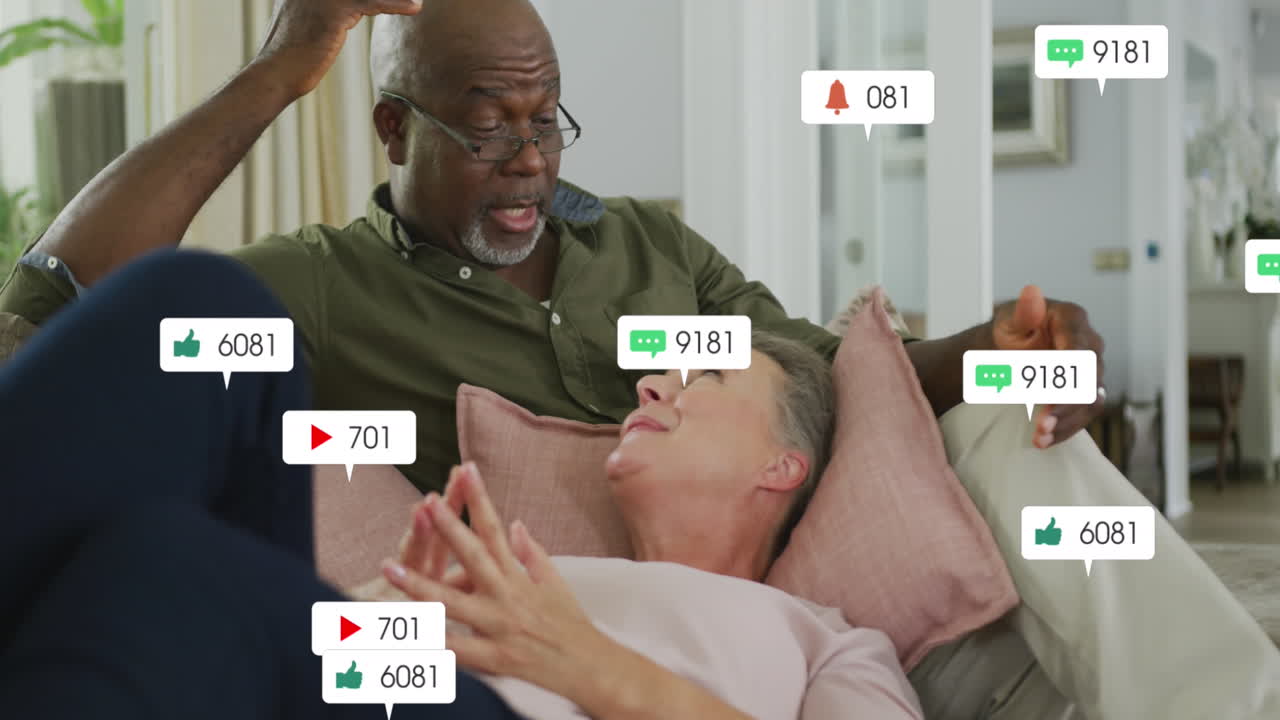 Animation of social media icons and numbers over senior diverse couple at home