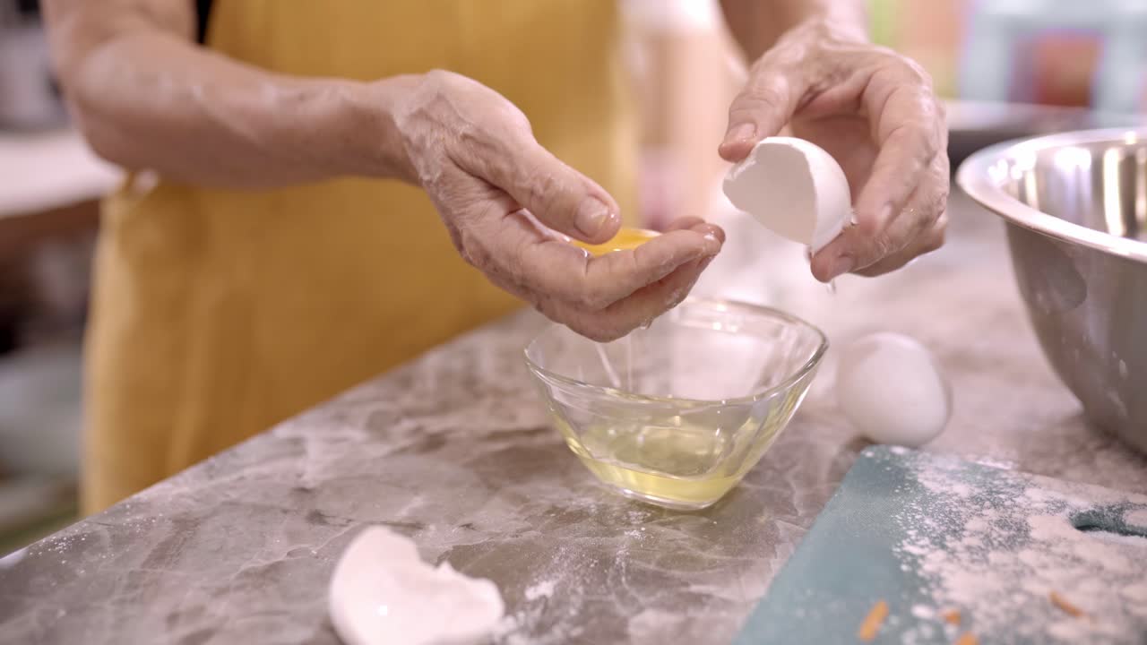 mujer de cultivo separando la yema de huevo de la blanca en la cocina