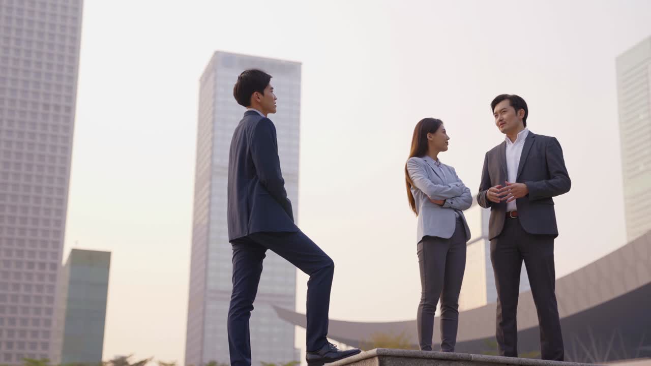 아시아 사업가들이 야외에서 이야기하고 있습니다.