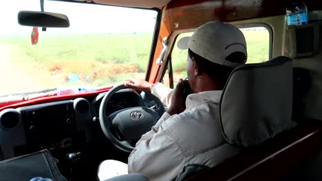 Blick-In-Ein-Safariauto,-Während-Der-Reiseleiter-Fährt-Und-Ins-Radio-Spricht