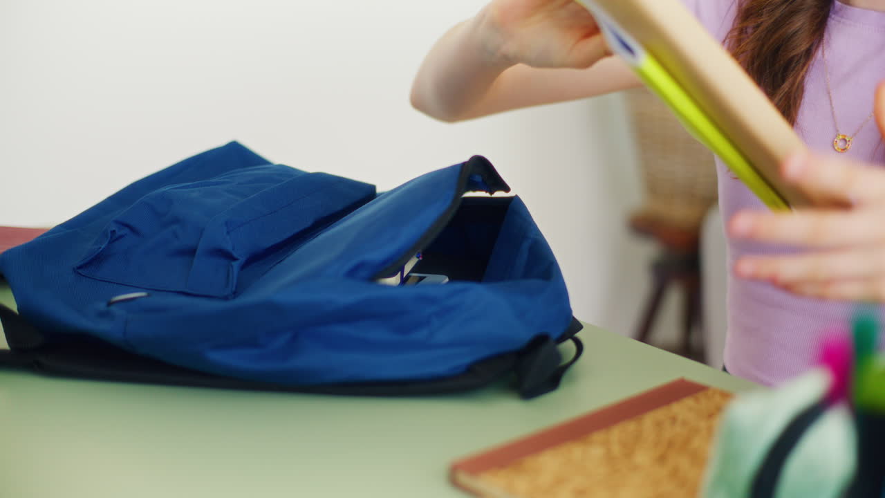 Close-Up of a Girl's Hands Taking Books Out of Her School Backpack