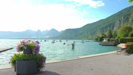 seepromenade of saint gilgen spa town with view to lake wolfgang and yachts and mountains in background